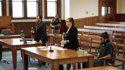 Christopher Stewart, right, sits in Belknap Superior Court Wednesday for a probable cause hearing on a charge of threatening a mass shooting at UNH, while his attorney, Erin Ferry, center, addresses the court. Shown standing at left is Assistant County Attorney Whitney Skinner. (Jon Decker/The Laconia Daily Sun photo)
